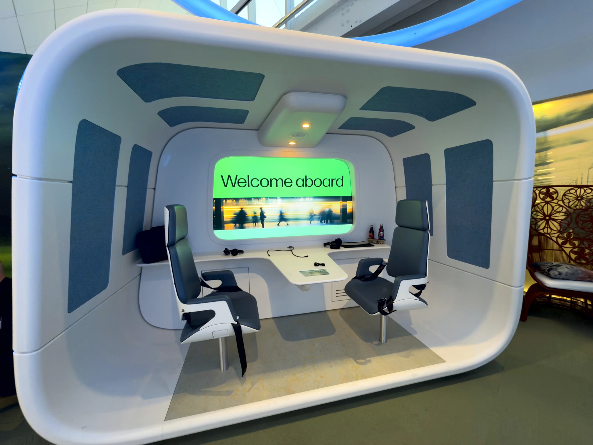 Immersive welcome-aboard experience pod with harness seats and a panoramic screen