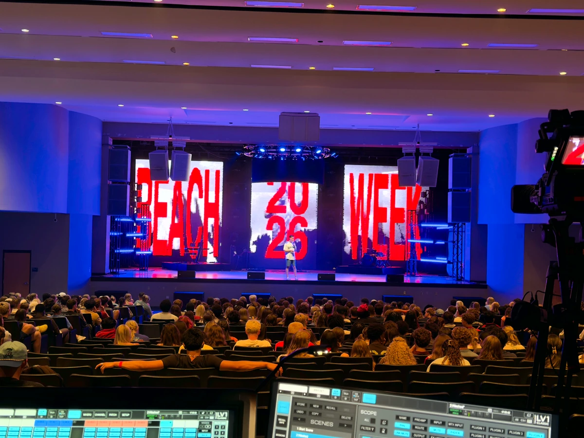 Line-array PA flown above a packed live-event floor at front-of-house