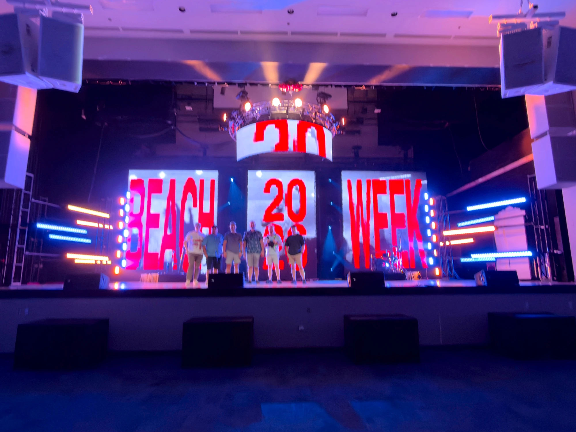 Space City Pro crew on the Beach Week stage during the build, with the LED wall and color-bar towers lit behind them