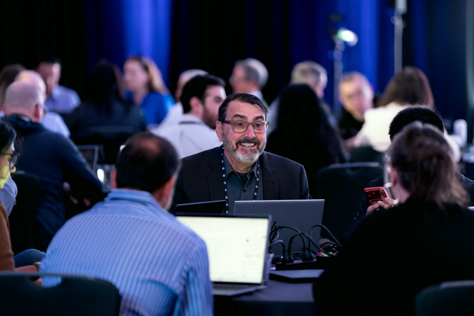 Breakout working session in progress: attendees at tables with laptops, mid-discussion