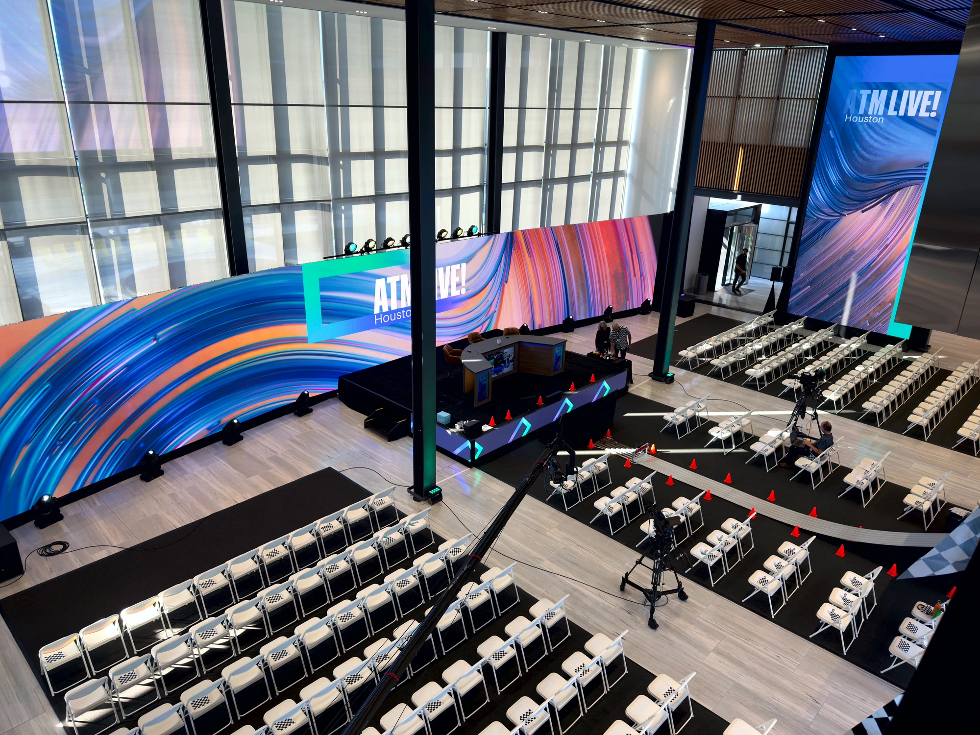 Elevated wide of the full ATM Live room: curved LED wrap and theater seating