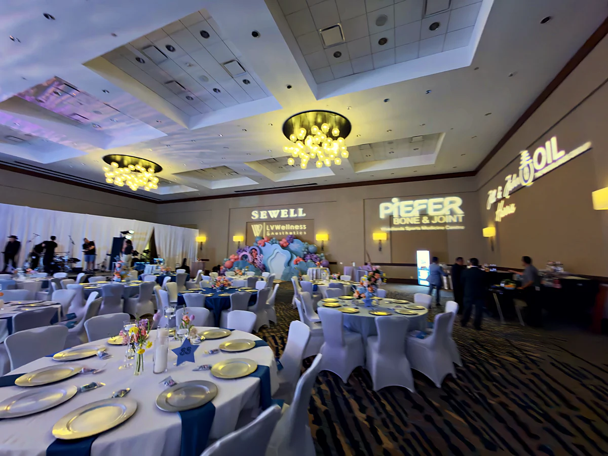 The St. Anthony Silver Star Jubilee gala room at scale with welcome wall and gobo lighting